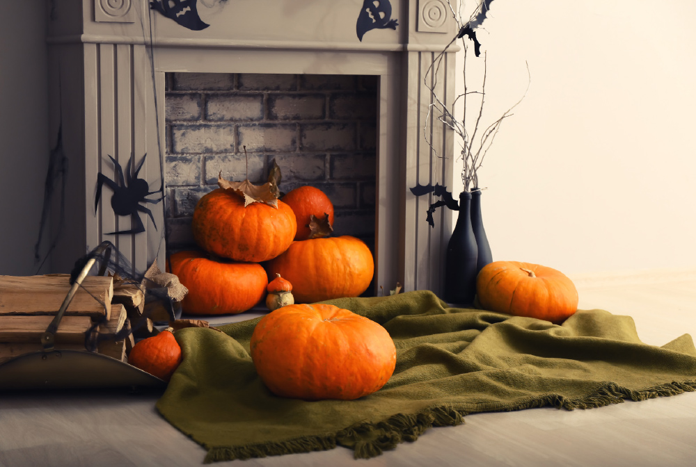 If you don’t have flames to warm up your fireplace, try firey 
orange pumpkins! Add a cut out spider to complete the look.