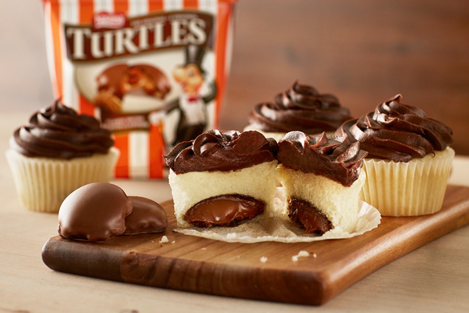 Recette de cupcakes aux gemmes cachées TURTLES. TORTUES entières cuites dans un gâteau moelleux, ces délicieuses friandises surprendront et raviront à coup sûr.
